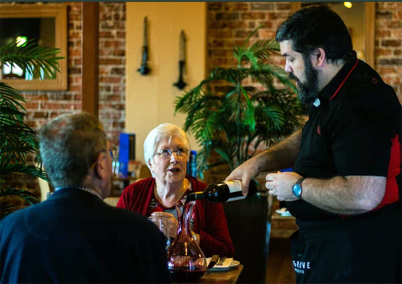 Rustlers Owner Les pouring wine for a customer